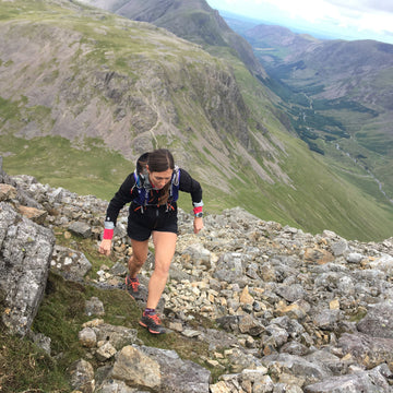 Trail runner using trekking poles in the Alps
