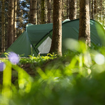 Campers sitting outside a bell tent