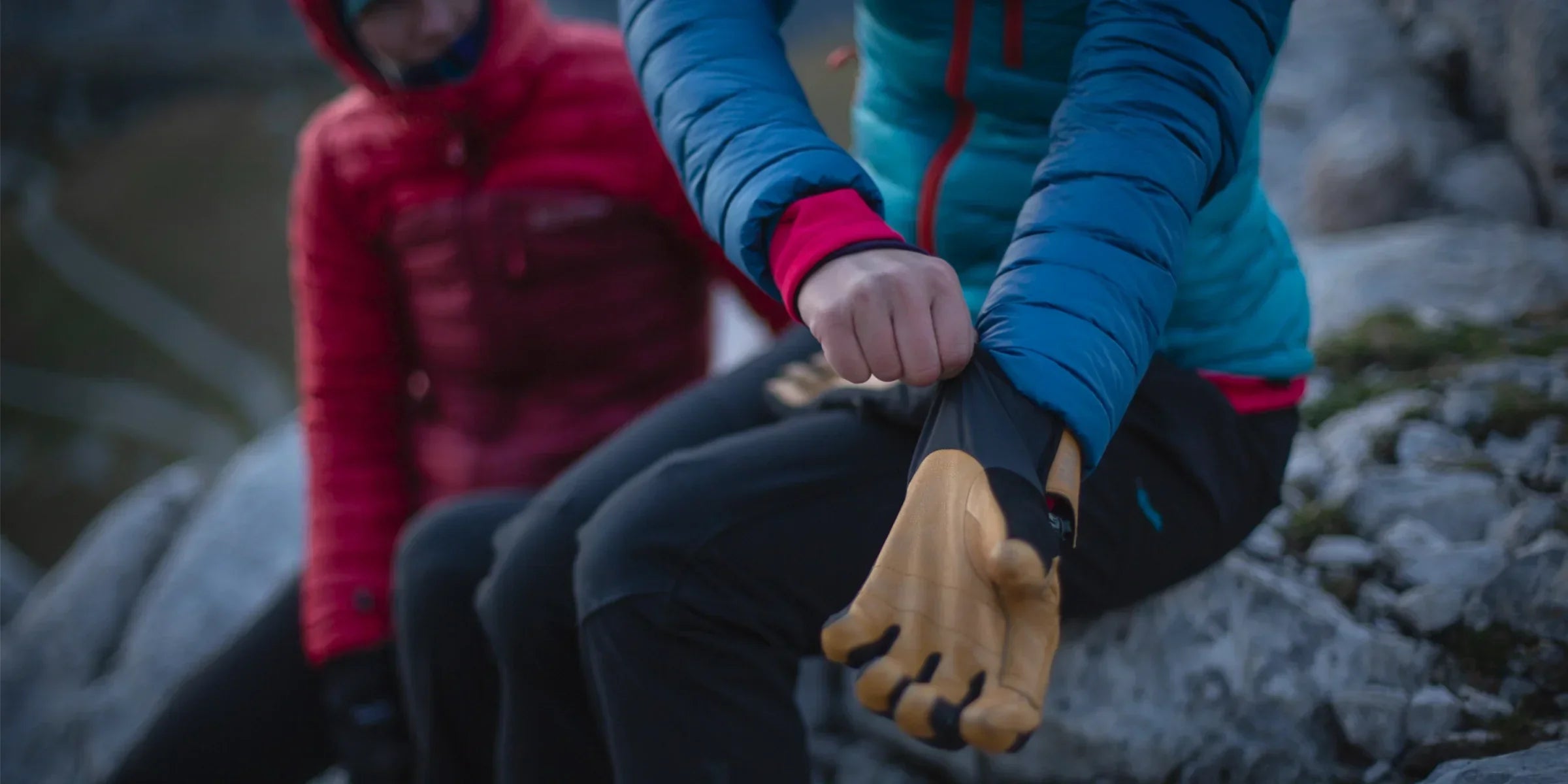 Climber pulling on gloves in the mountains