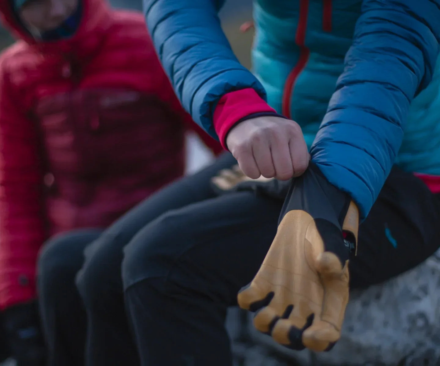Climber pulling on gloves in the mountains