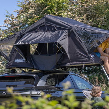 Campers sitting outside a bell tent