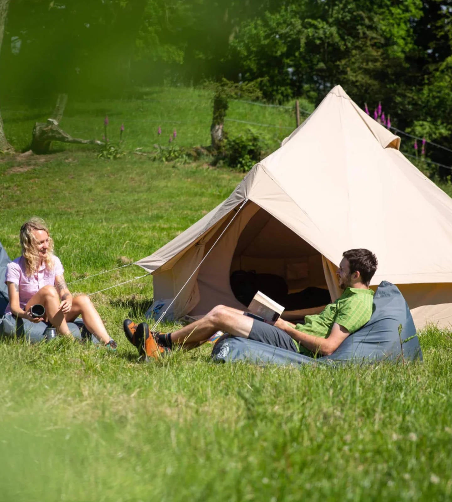 Campers sitting outside a bell tent