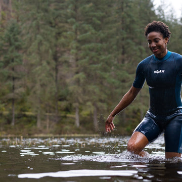 Swimmer wading out into a sea loch