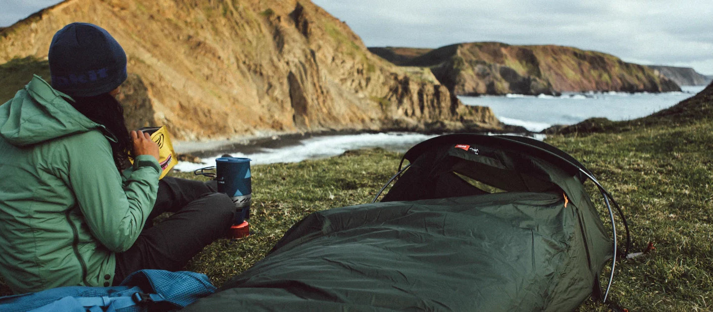 A camper enjoys a lighweight summer bivvy on a clifftop