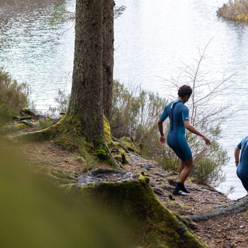 Swimmer wading out into a sea loch