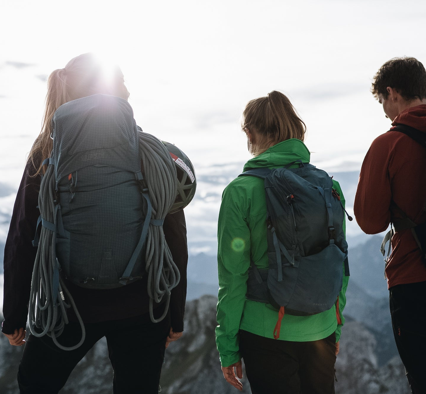 Hikers wearing different sized rucksacks atop a mountain