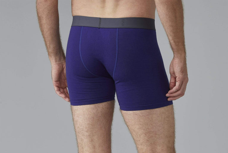 A man modeling blue merino boxers from the back