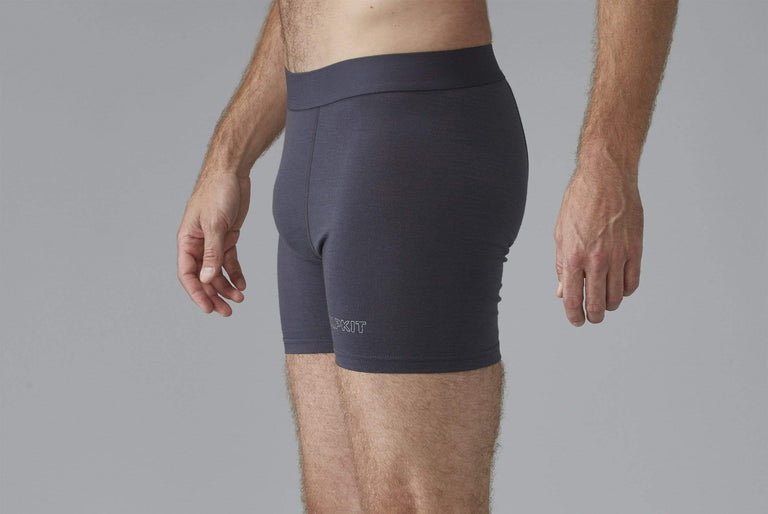 A side view of a man modelling grey merino wool boxer shorts