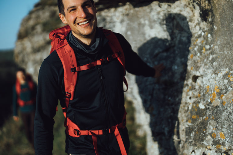 A man hiking in the Peak District in a black fleece jacket - action