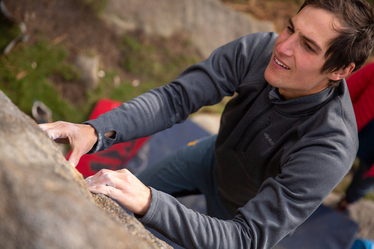 A man bouldering in a stretch fleece top - action